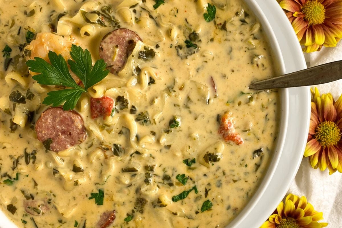 Shrimp and sausage soup in a round white bowl. 