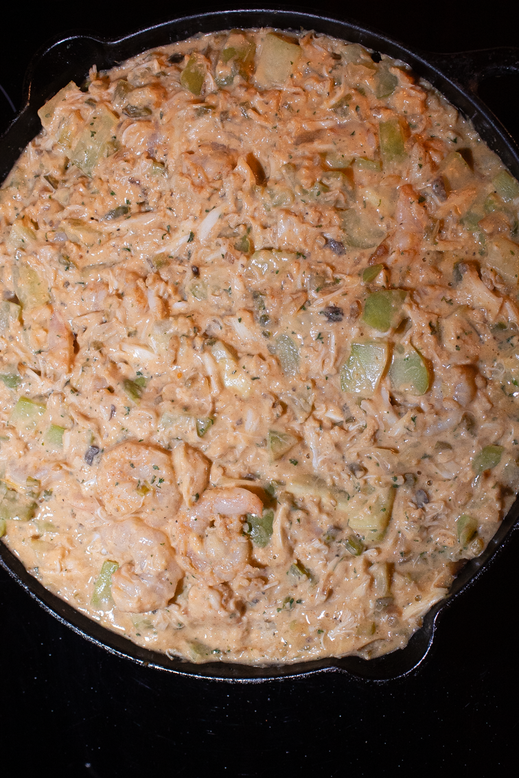 A skillet full of mirliton dressing about to be put into the oven.