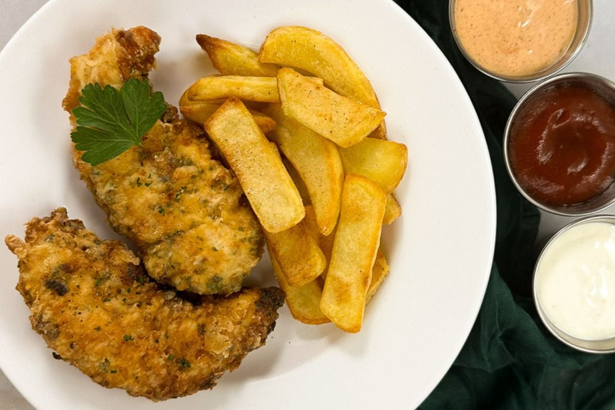 Cajun chicken tenders with fries on a plate.