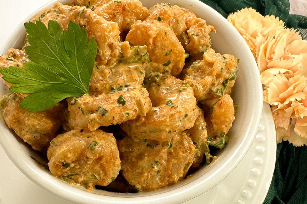 Cajun shrimp salad in a small white bowl.