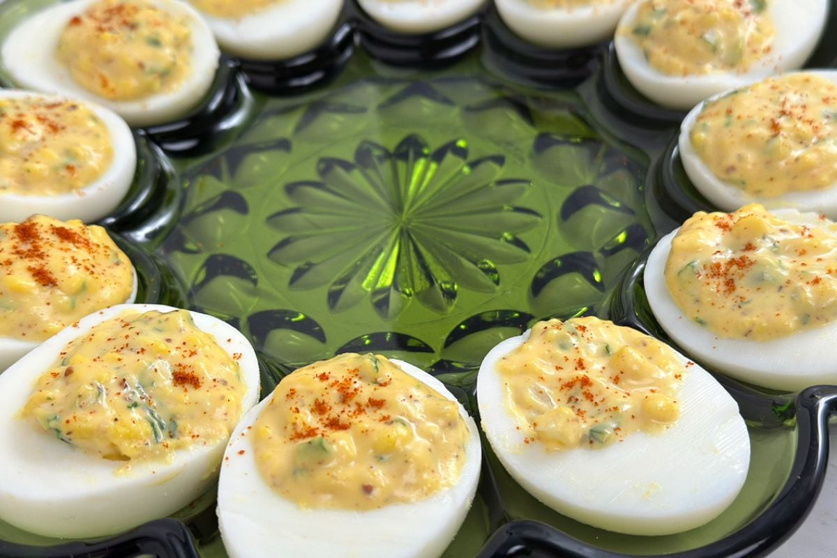 A side shot of Cajun deviled eggs in a vintage green serving platter.