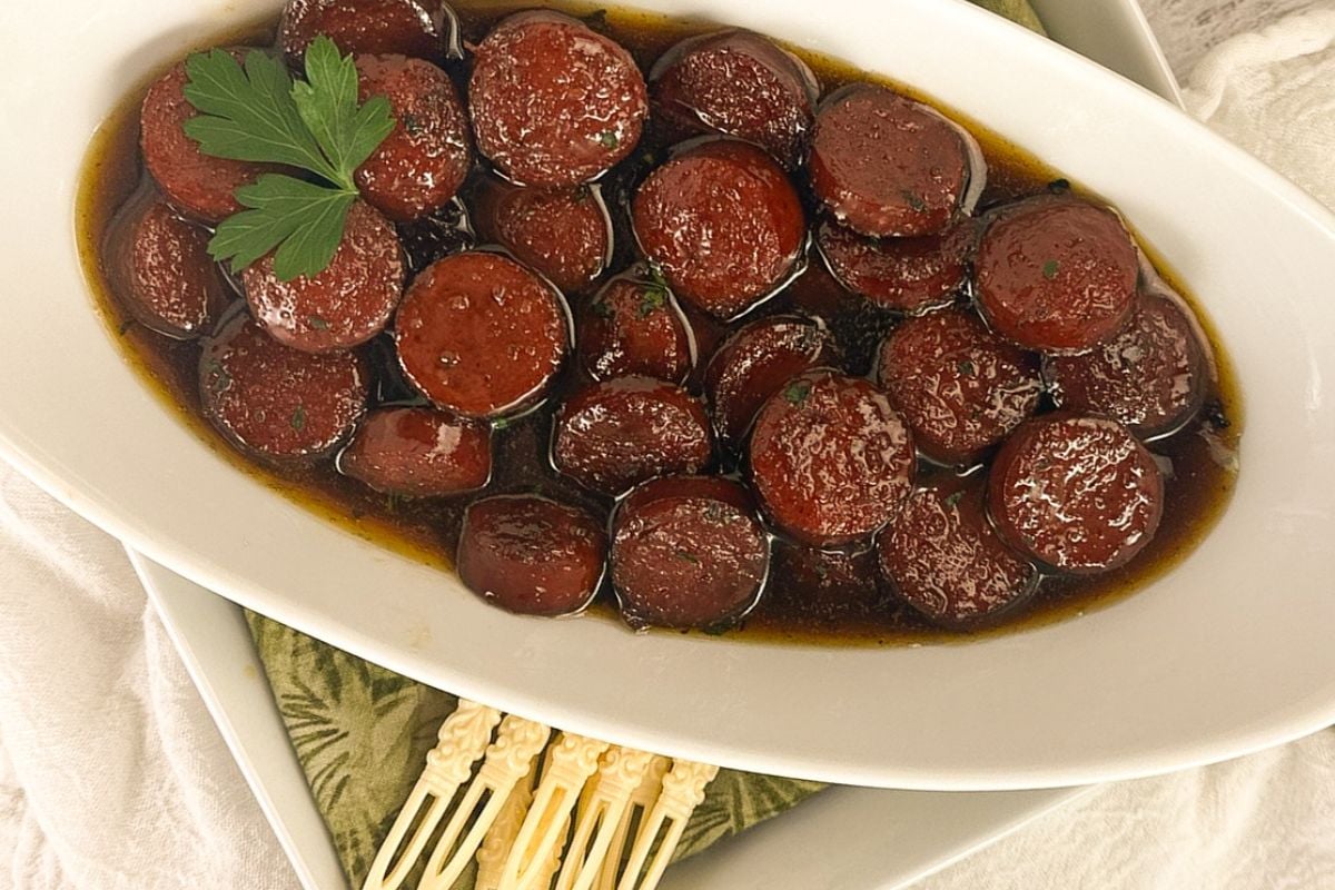 Beef sausage bites in an oval white serving dish.