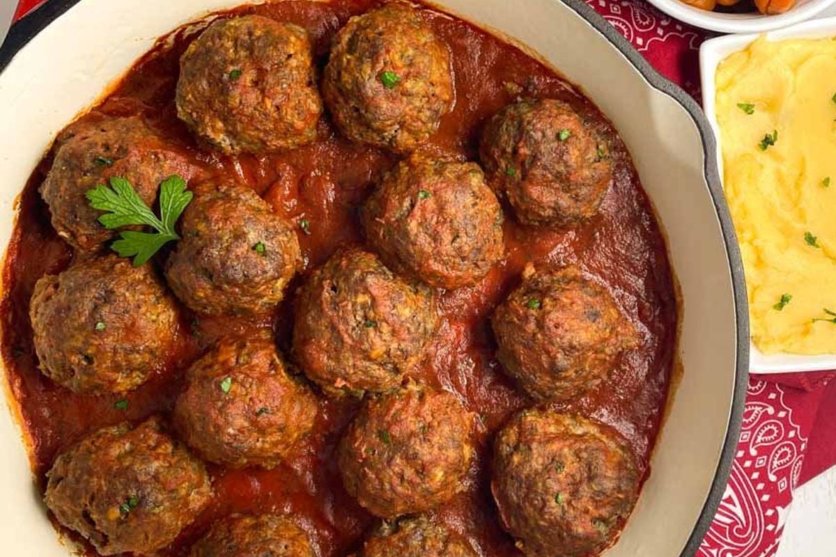 Creole meatballs in an enameled cast iron skillet.