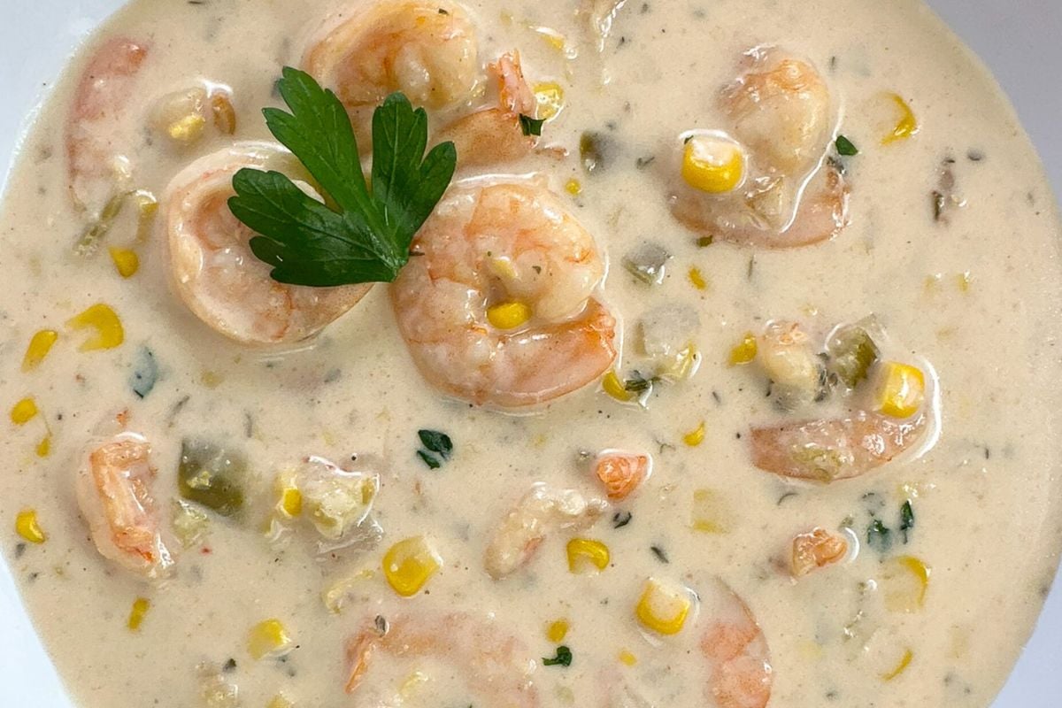 One of the most requested Cajun Christmas recipes, shrimp and corn bisque in a round white bowl. 