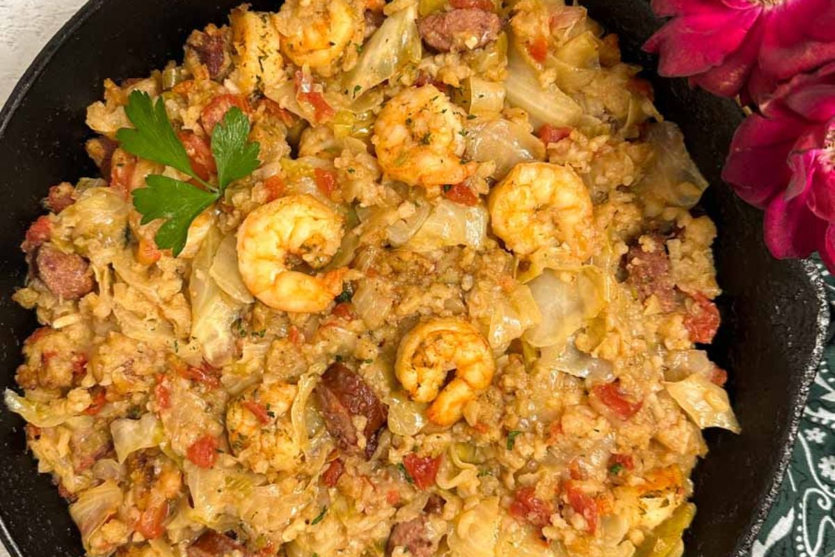 Cajun cabbage jambalaya in a black cast iron skillet.