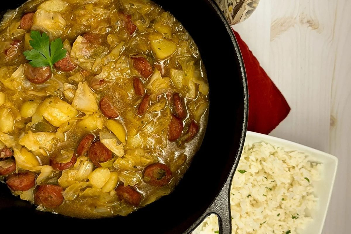 Cajun cabbage stew in black cast iron pot.