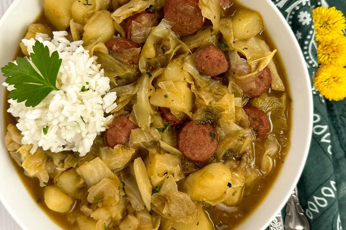 Cajun cabbage stew in a round white bowl.