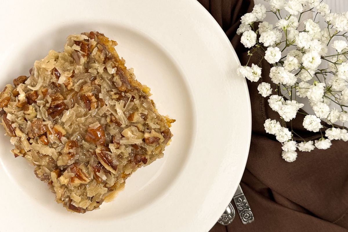 A slice of Cajun cake on a round white plate, one of the oldest and most celebrated of the Cajun Christmas recipes. 