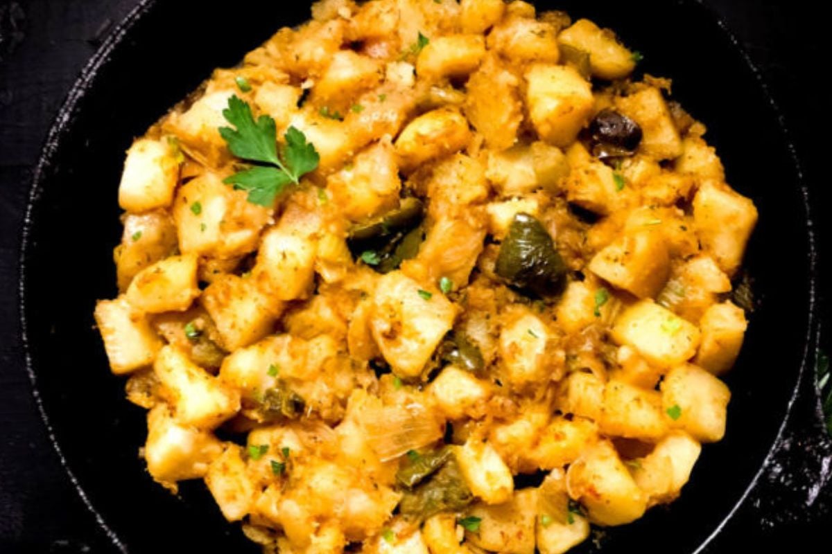 Cajun smothered potatoes in a cast iron skillet. 