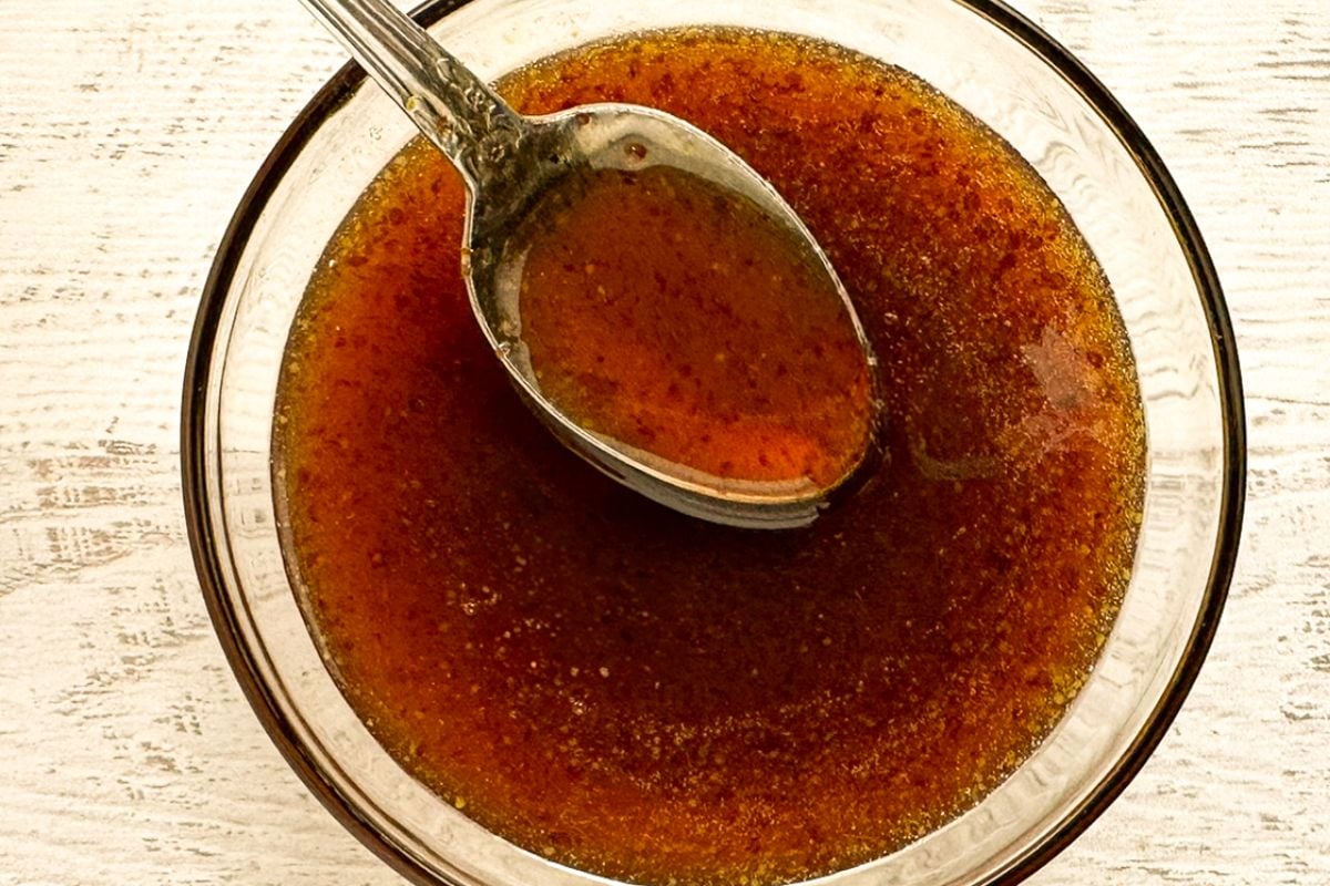 Creole honey mustard glaze in a clear glass bowl with a spoon. 