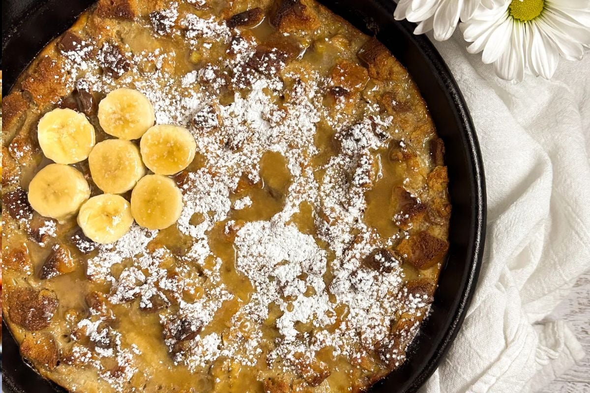 Bananas Foster bread pudding in a black cast iron skillet.