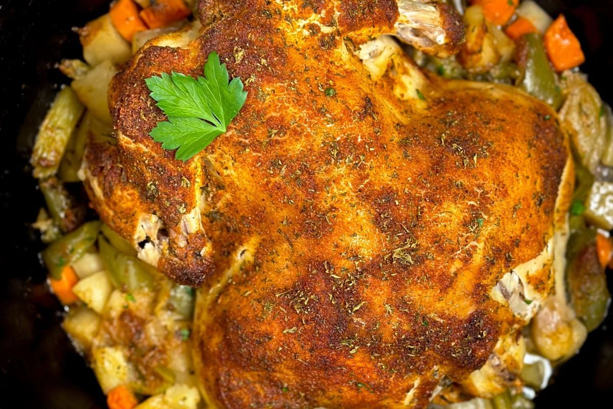 Cajun roasted chicken and veggies in a large cast iron Dutch oven.