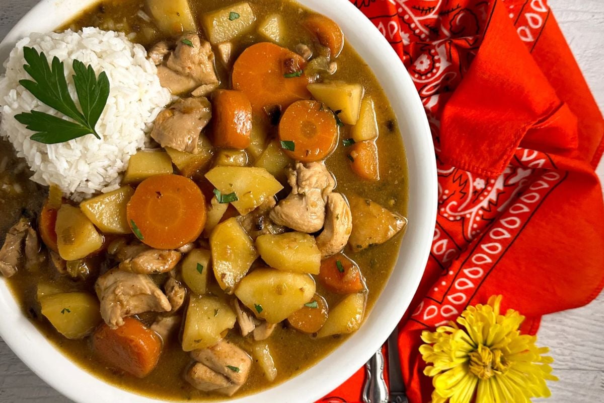 Cajun chicken stew in a round white bowl.