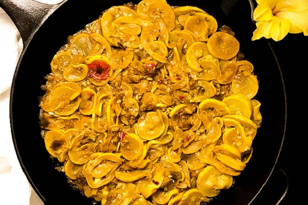 Cajun smothered squash in a black cast iron skillet.