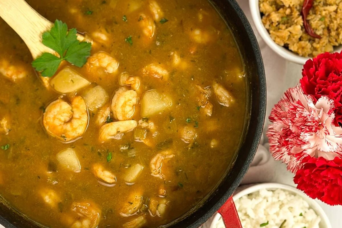 Cajun shrimp stew in a red enameled cast iron Dutch oven.