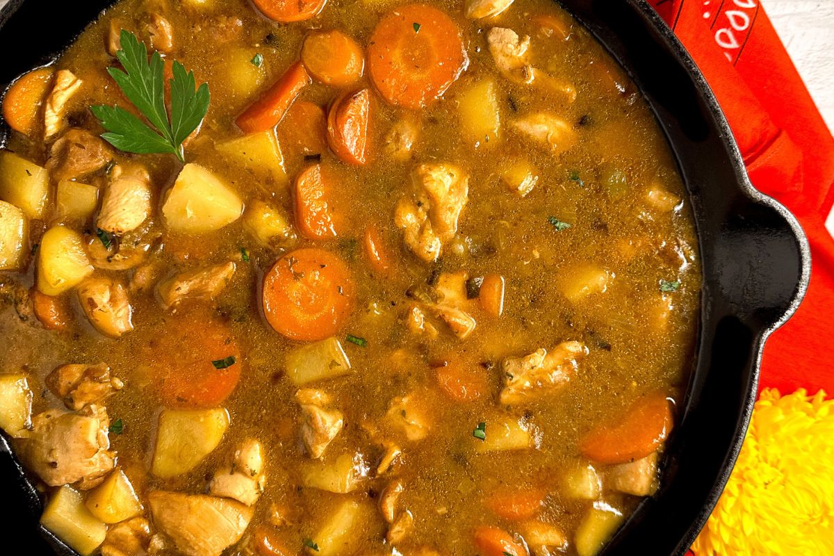 Cajun chicken stew in a black cast iron skillet.