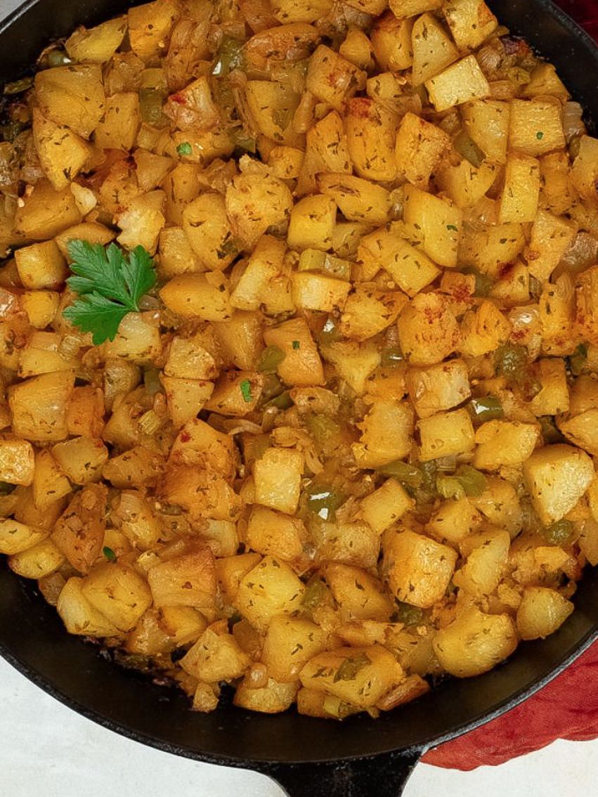 Super closeup of Cajun roasted potatoes in a black cast iron skillet.