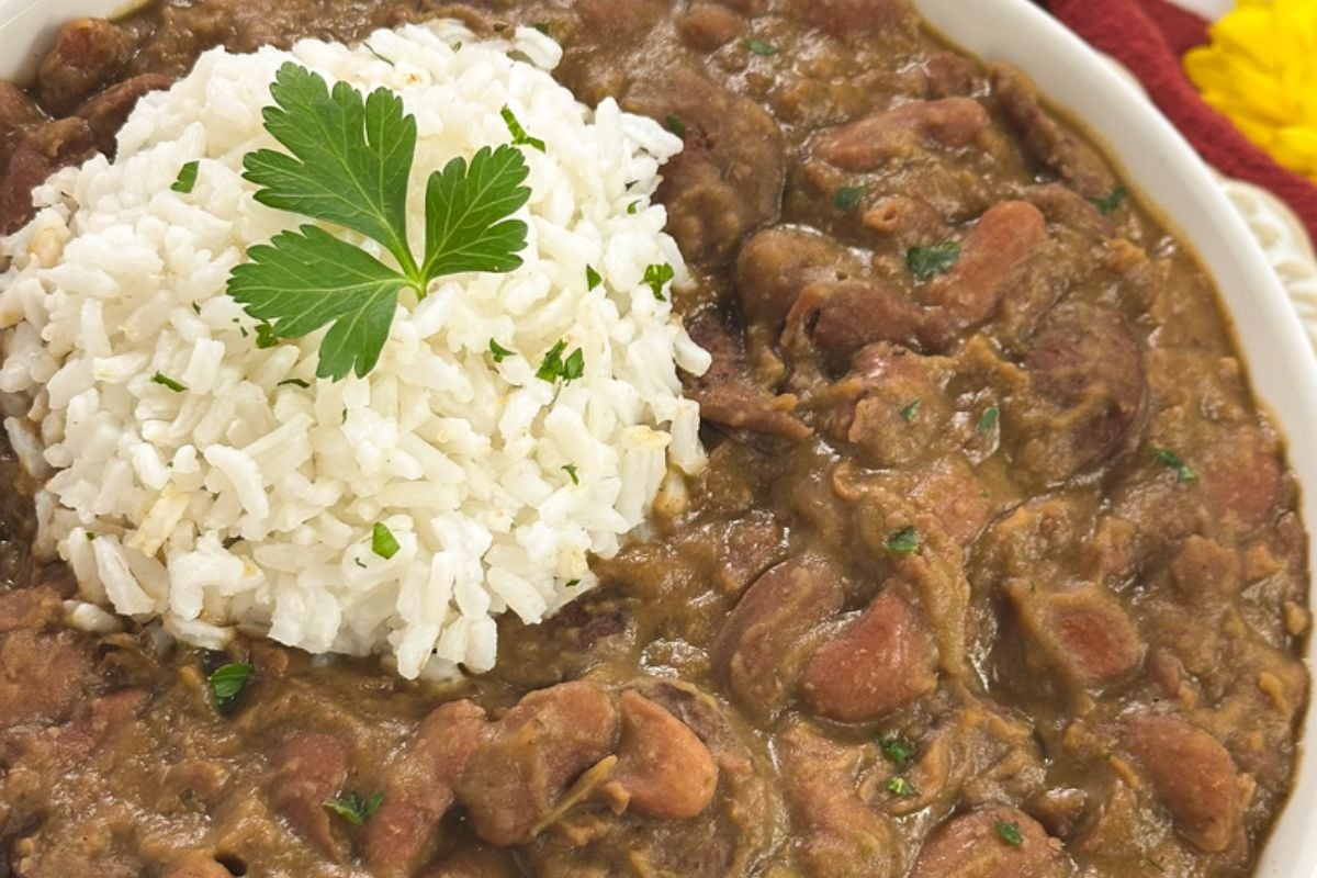 Louisiana red beans and rice with a whole parsley leaf garnish on the top of the rice. 