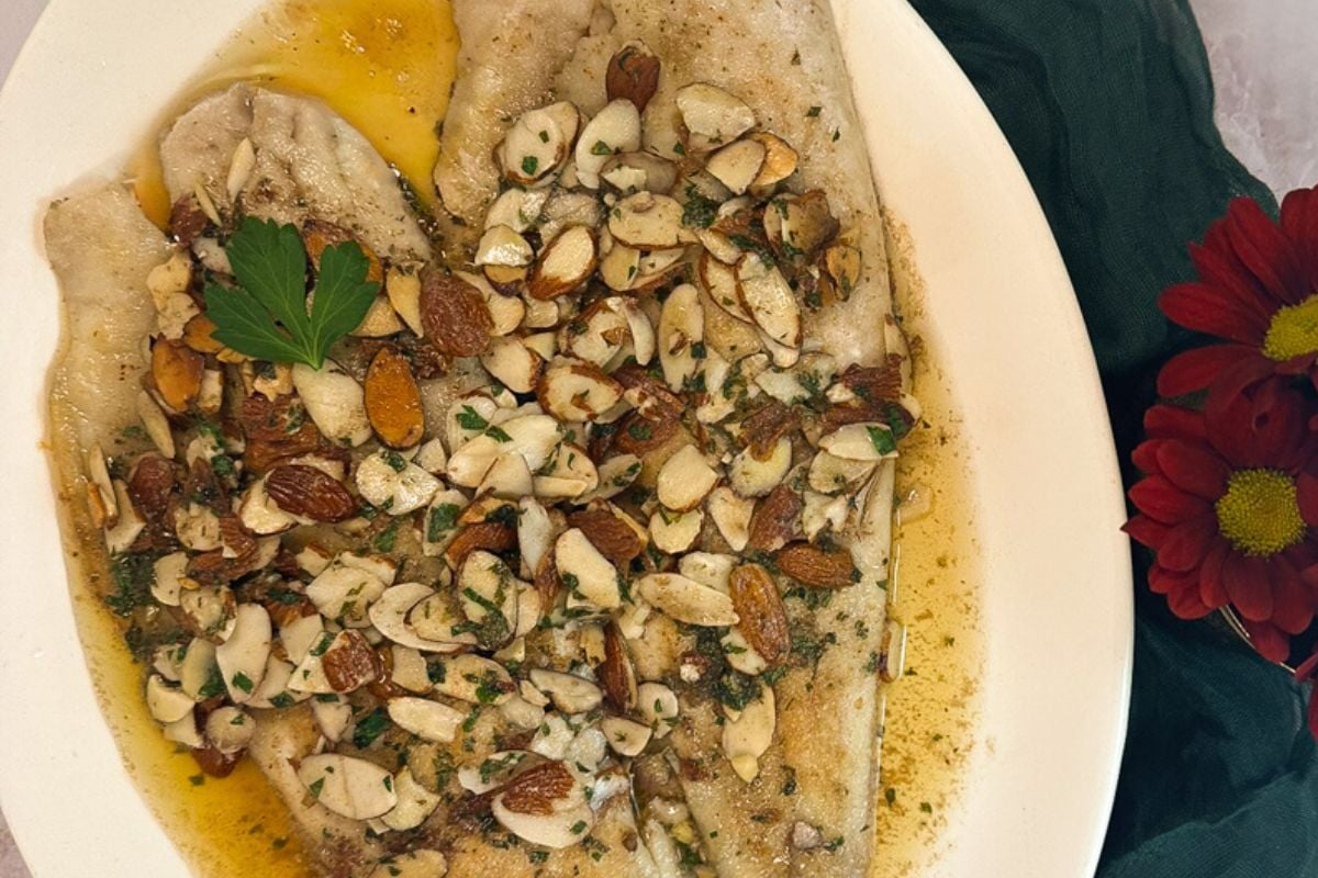 Trout amandine on a white serving plate.