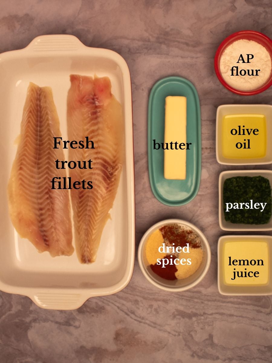 Labeled ingredients for trout Meuniere in bowls on a bedrock-colored background.