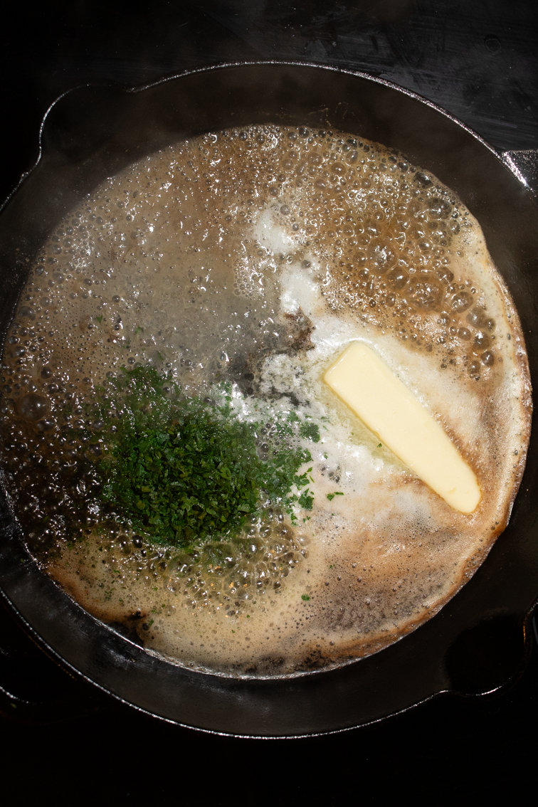 Butter, lemon juice and parsley in a skillet on the stove.
