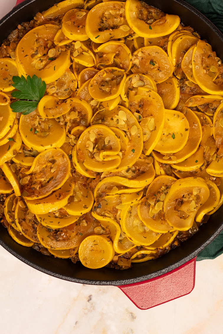 A super closeup shot of Cajun smothered yellow squash in a pan. 