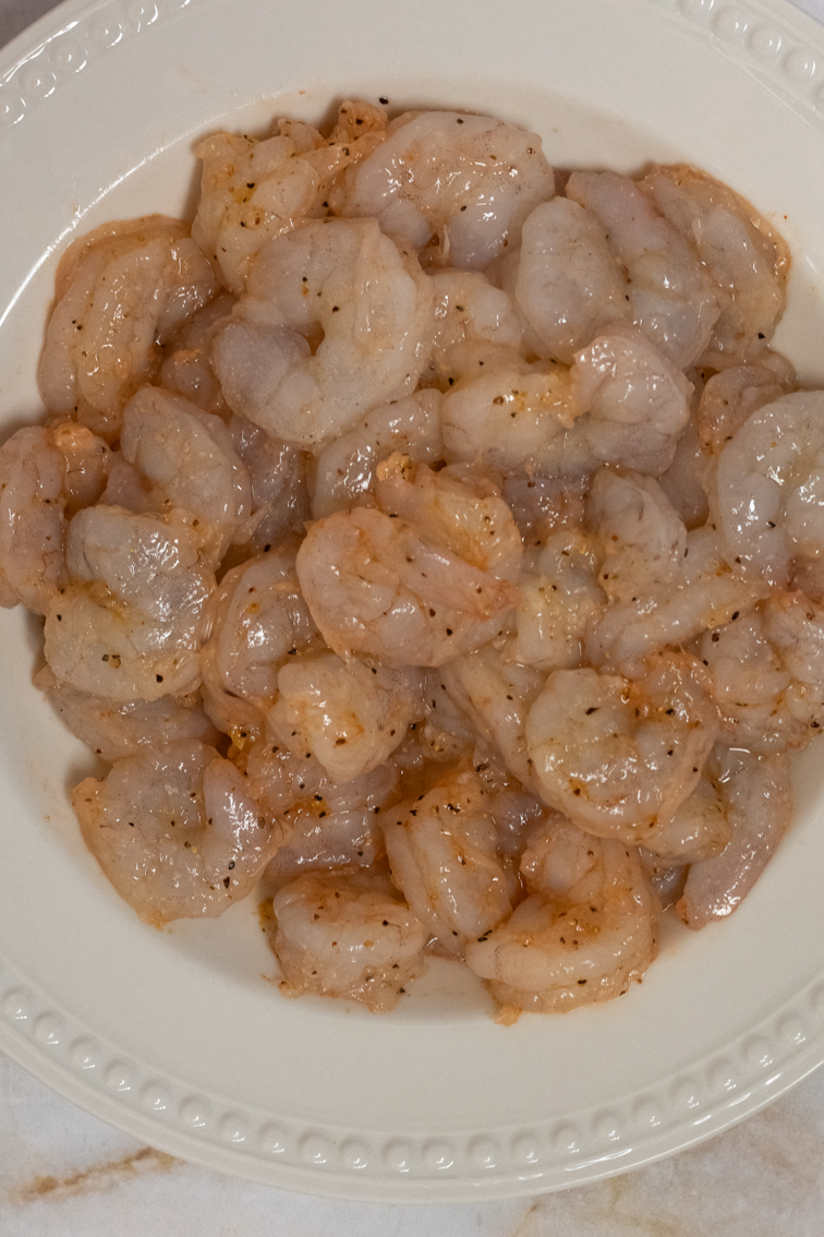 Seasoned shrimp in a white bowl.