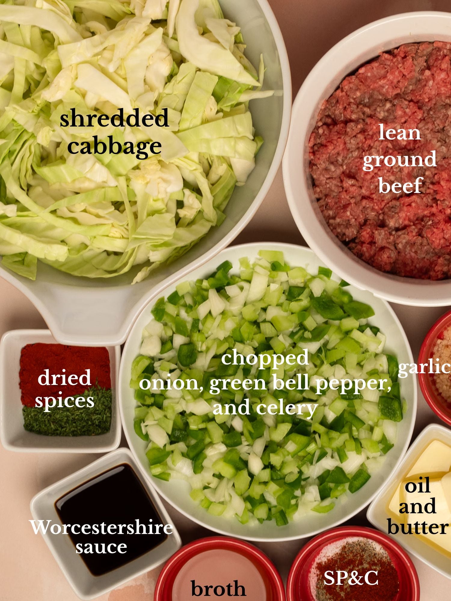 Ingredients for ground beef and cabbage in bowls on a peachy pink background. 