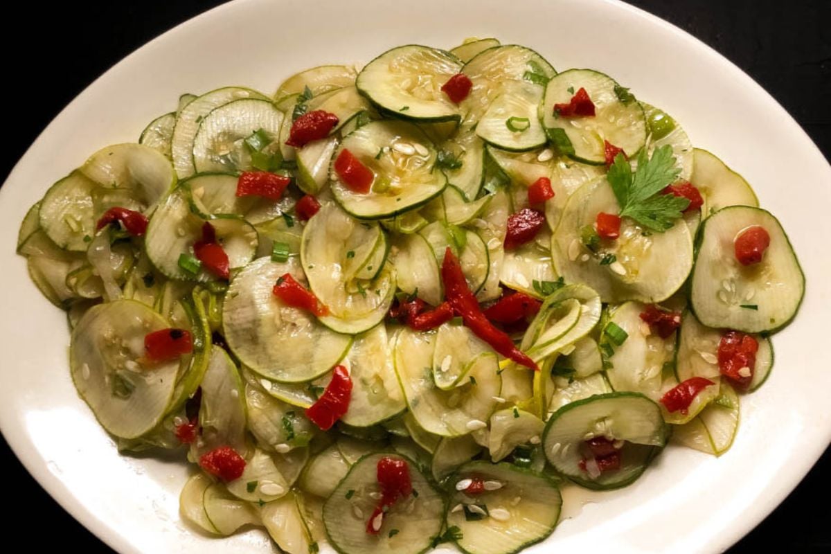 Cajun marinated cucumber salad on an oval white serving dish.