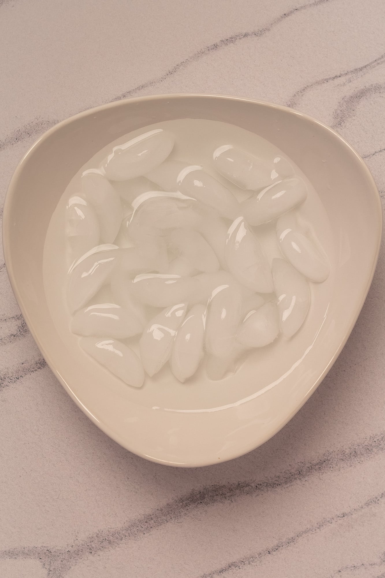 An ice bath in a white serving dish.
