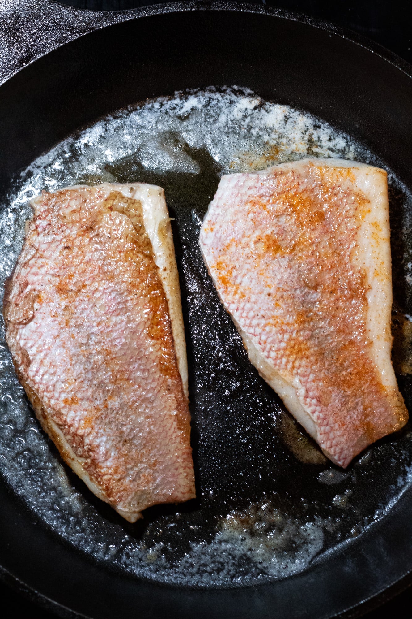 Pan seared snapper in a skillet.