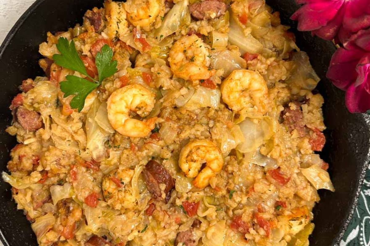 Cabbage jambalaya in a black cast iron skillet.