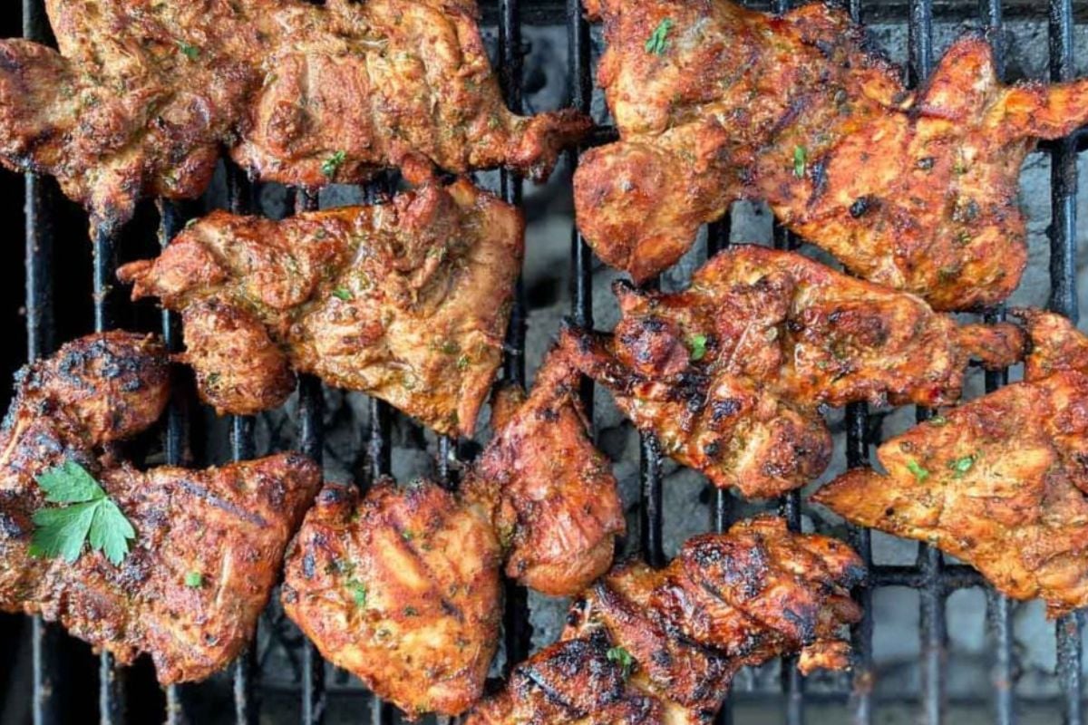 Boneless chicken thighs on a grill.