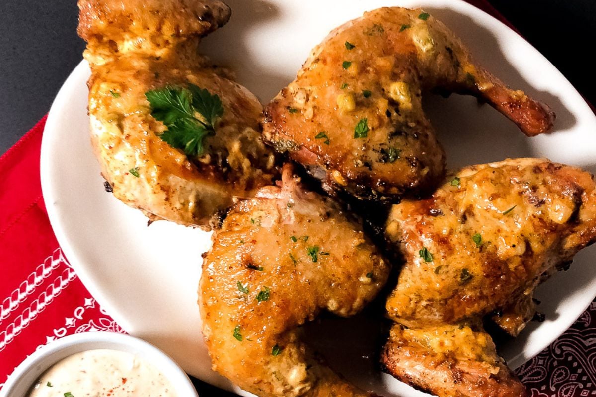 Grilled chicken remoulade pieces on a white serving platter. 