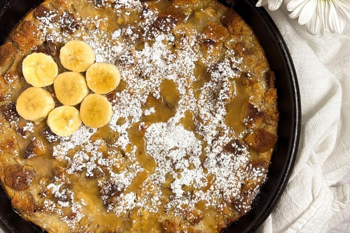 Bananas Foster bread pudding in a black cast iron skillet. 