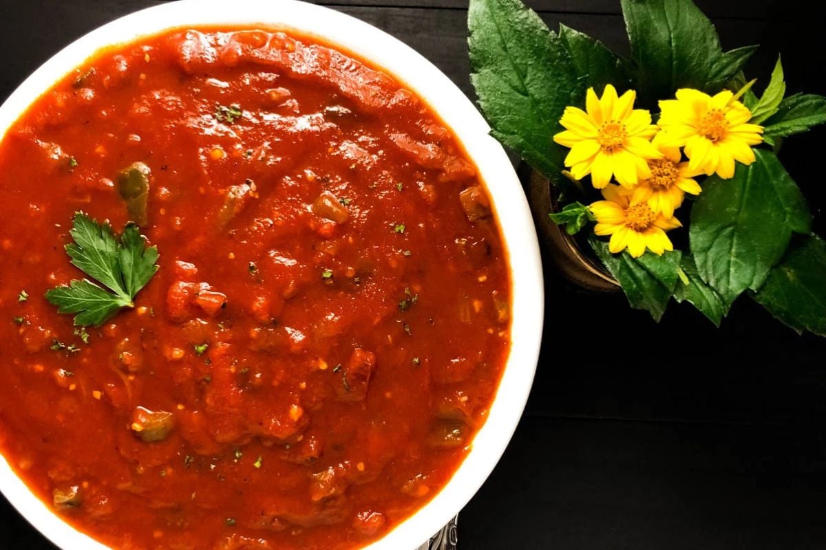 Baked red gravy in a round white bowl. 