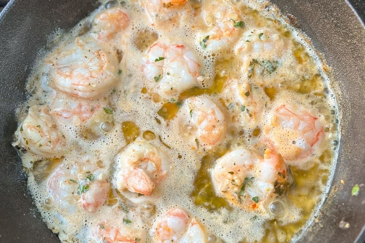 Lemon butter shrimp sauce in a cast iron pot on the grill. 