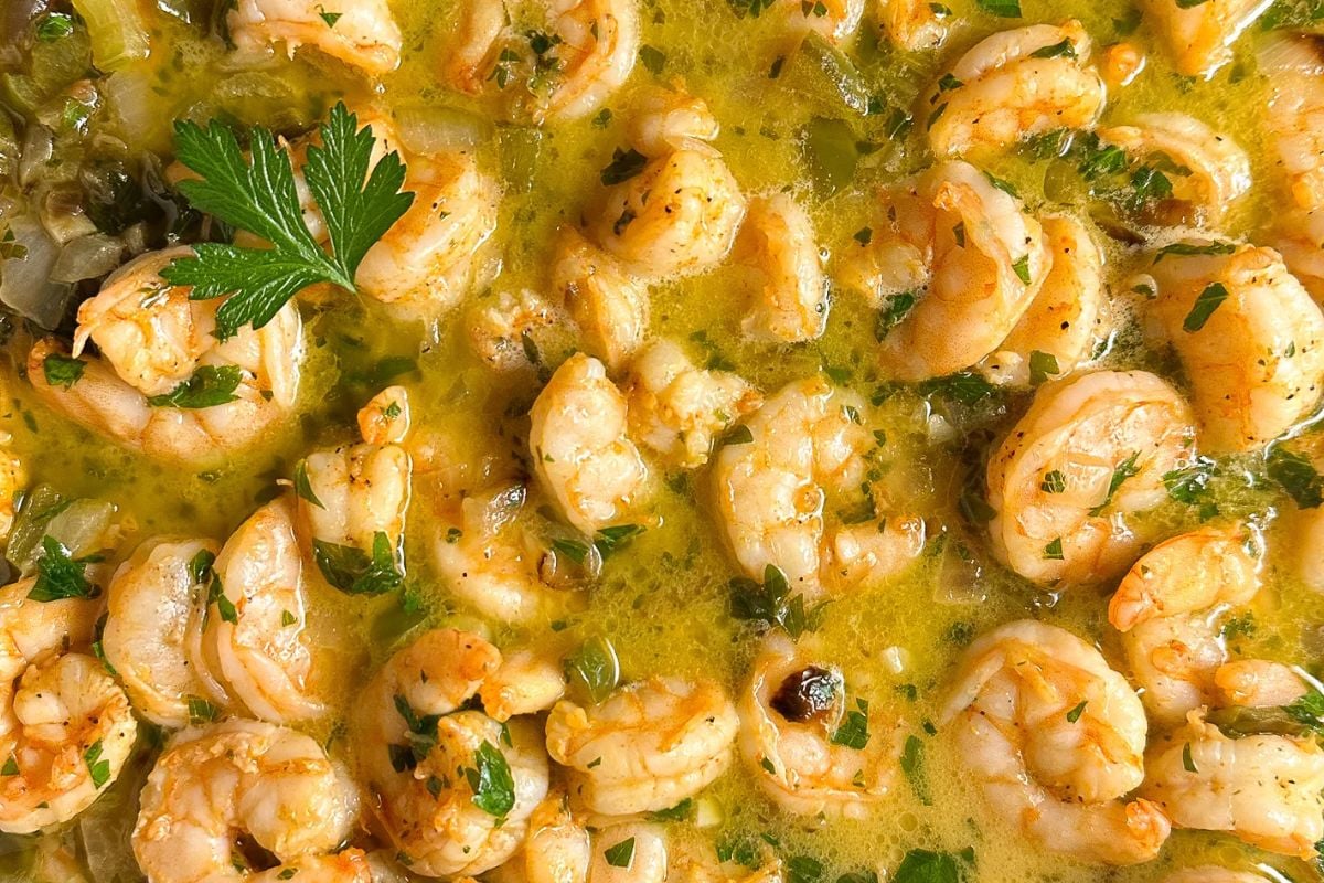 A closeup of Cajun shrimp scampi sauce in a large heavy skillet. 