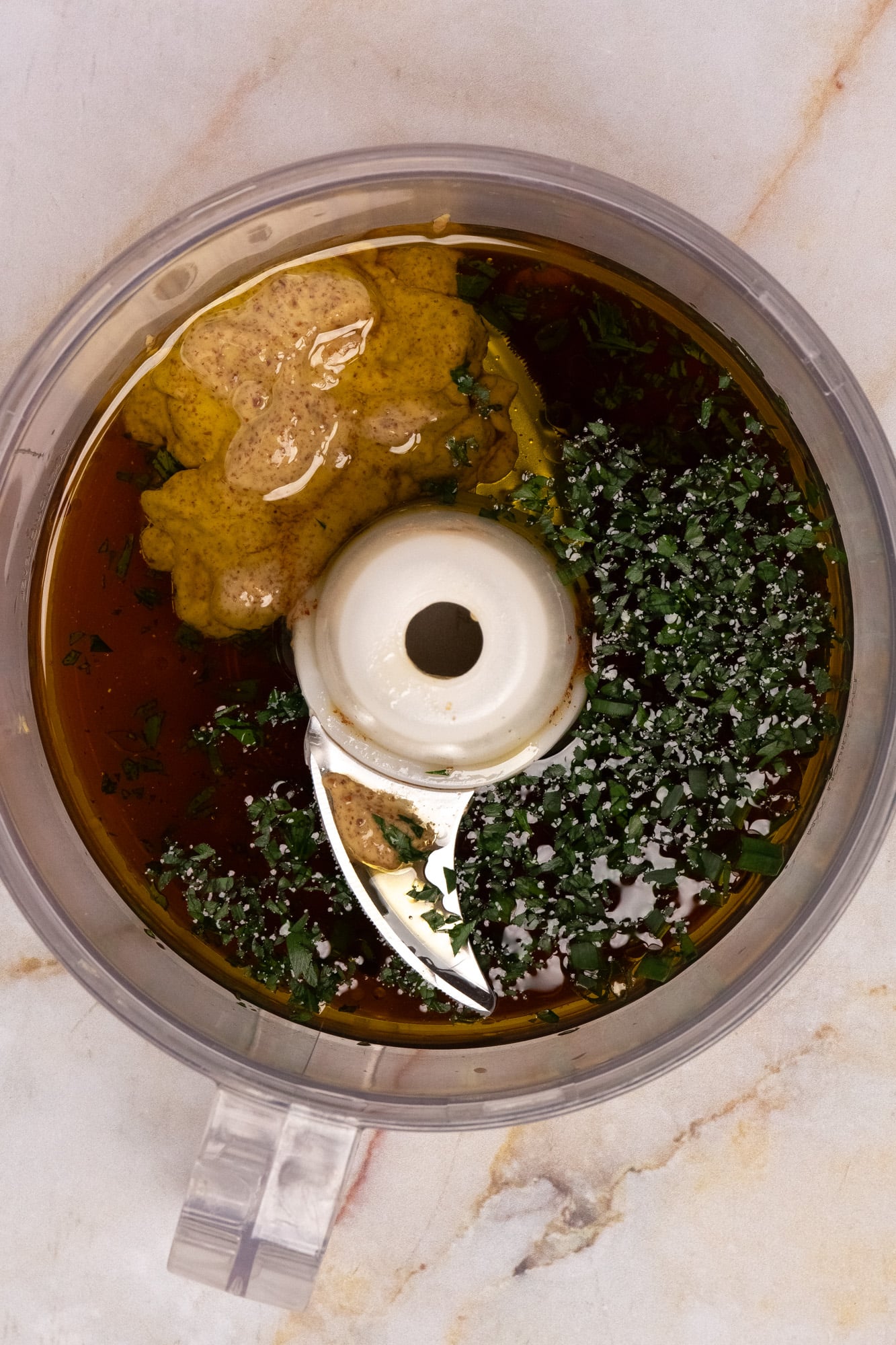 Ingredients for homemade dressing in the bowl of a food processor.