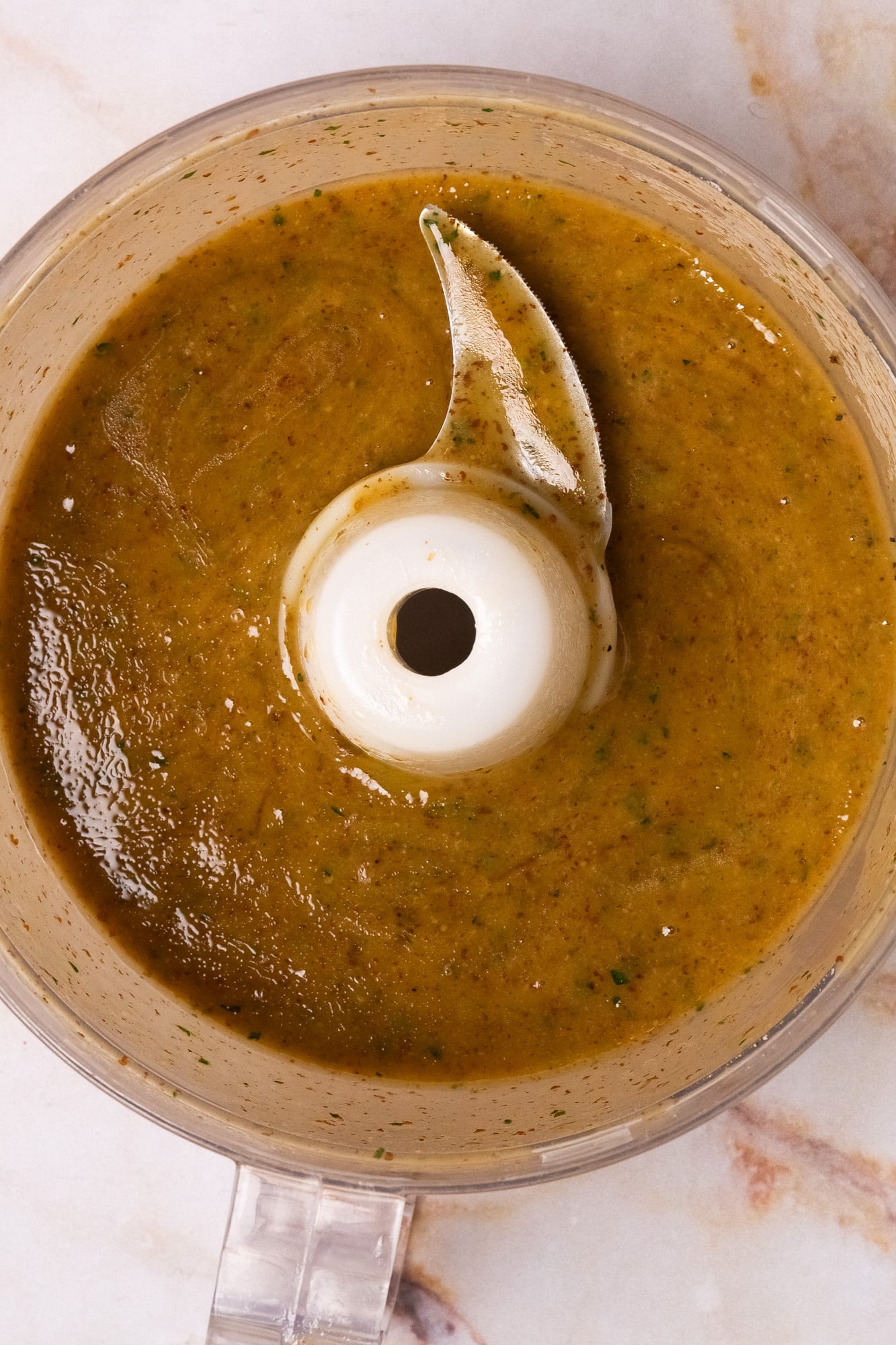 Creole mustard dressing in a clear food processor bowl.