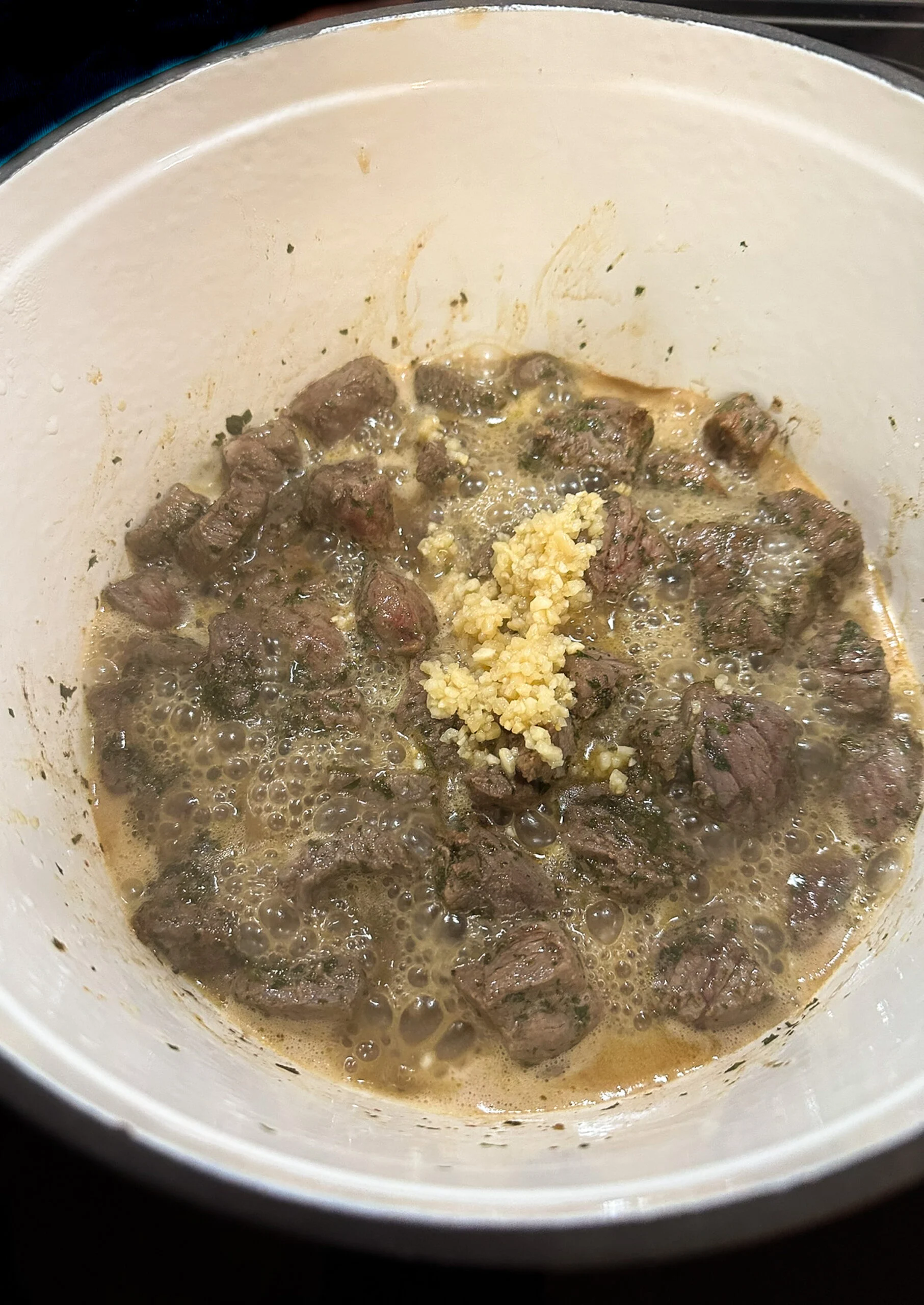 Browned steak with garlic in a pot.