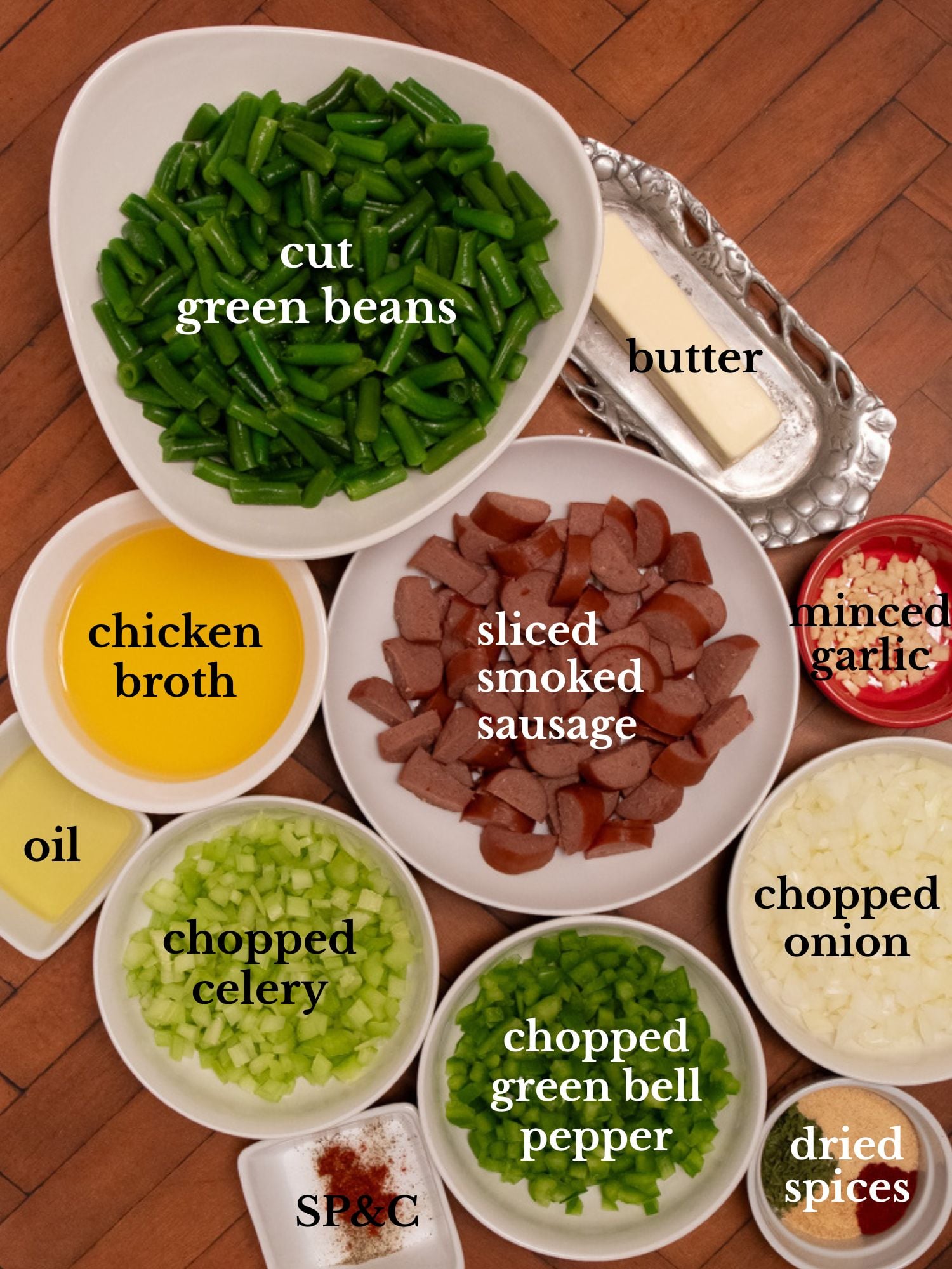 Ingredients for Cajun smothered green beans in bowls on a wooden backdrop.