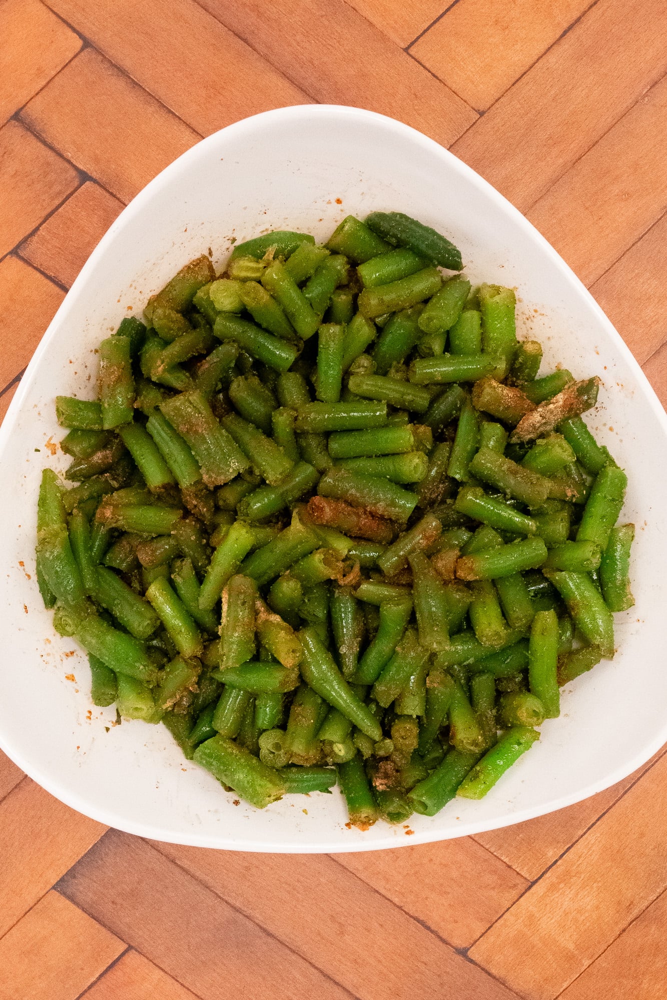 Seasoned cut green beans in a bowl.